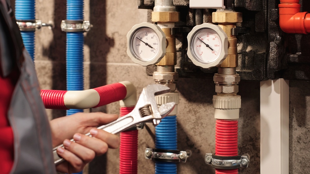 Sanitärinstallateur an Rohrleitungen mit Manometern